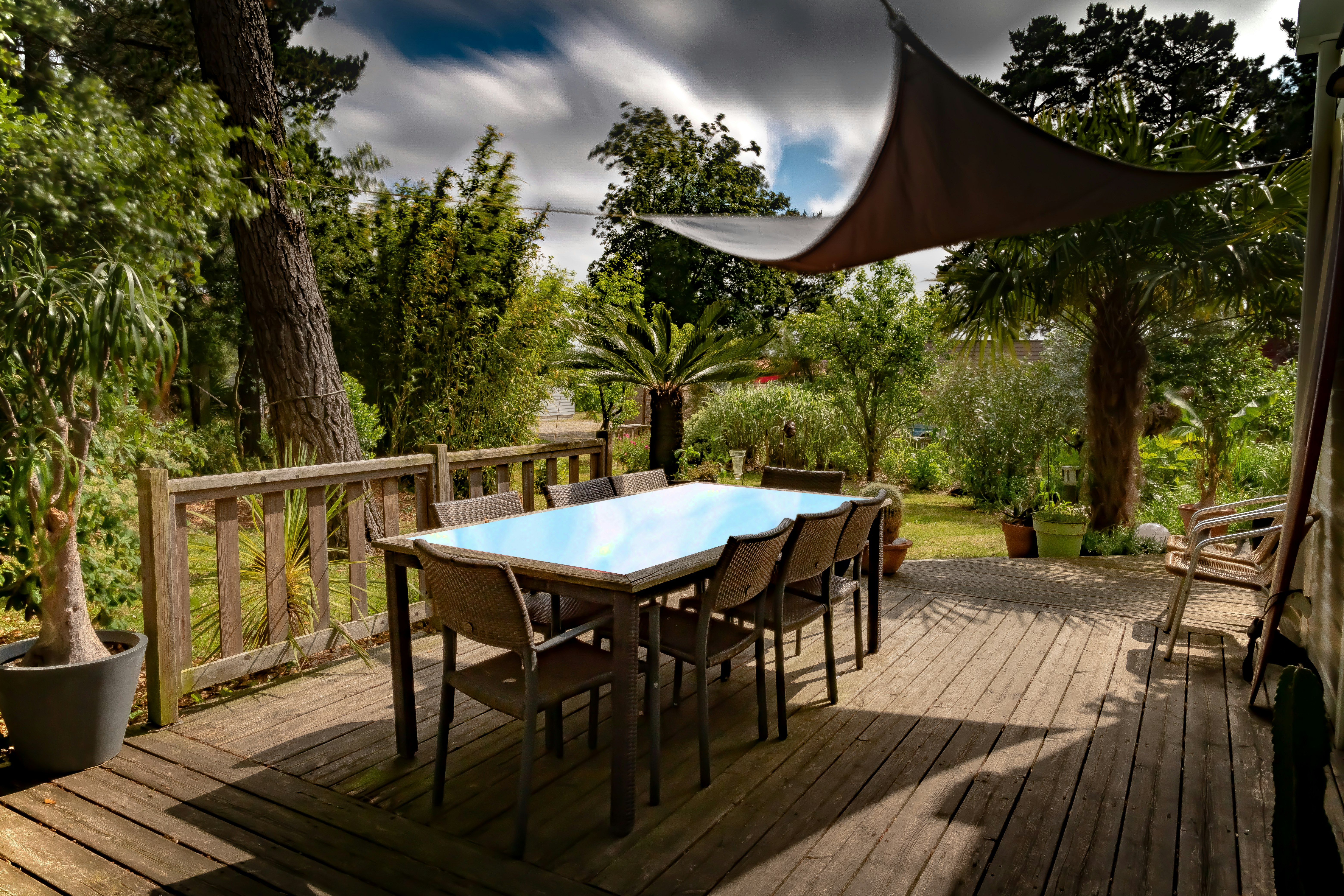 brown wooden table with chairs and umbrella